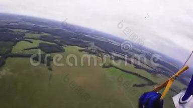 专业跳伞员乘降落伞飞越绿野森林。 身高。 阳光明媚